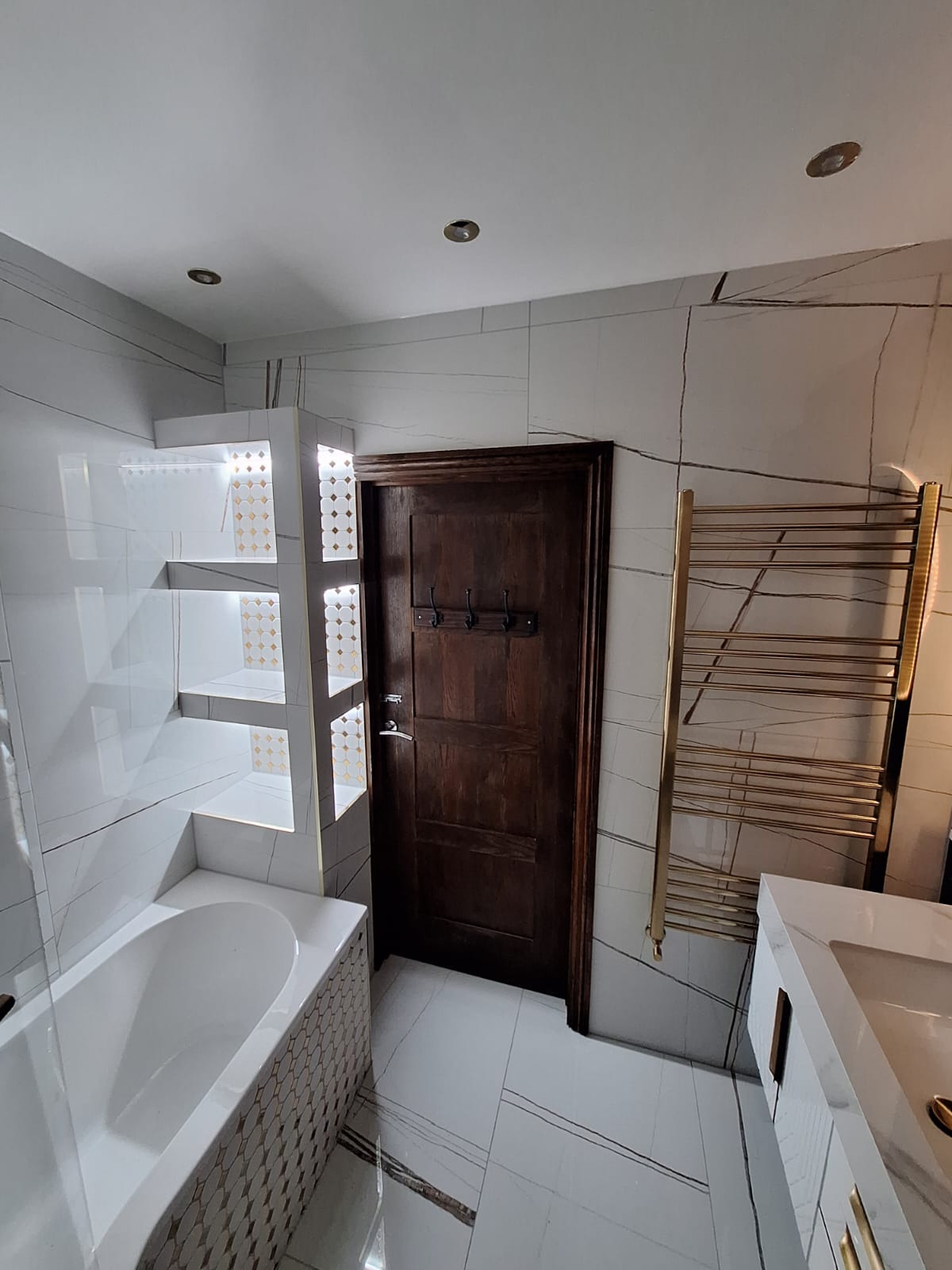 Backlit hex mosaic niches above the bath
